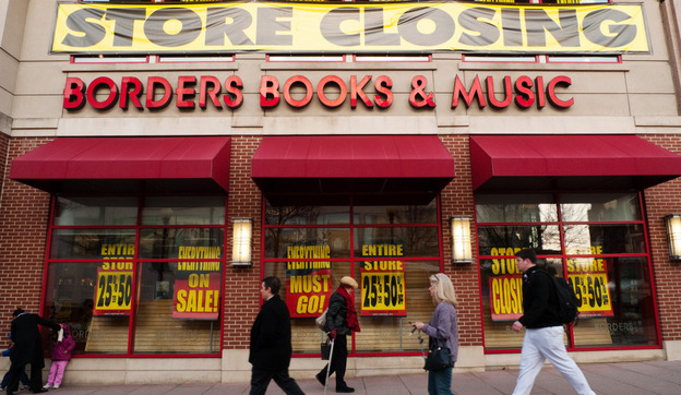 Pedestrians pass by a Washington, DC Borders book store with signs announcing it was closing: March 4, 2011.