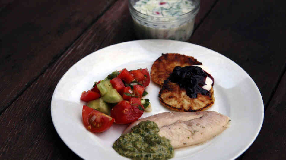 Traditional Soviet summer fare: a bowl of Okroshka (Cold Kefir Soup), Syrniki (Curd-Cheese Pancakes) with berries and sour cream, Grilled Trout with Tarragon and Cilantro Walnut Sauce, and Azerbaijan Salad.