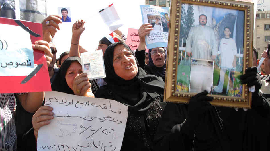 Women hold photographs and signs of their missing male relatives during a weekly protest in Baghdad's Tahrir Square. Women hold photographs and signs of their missing male relatives during a weekly protest in Baghdad's Tahrir Square.