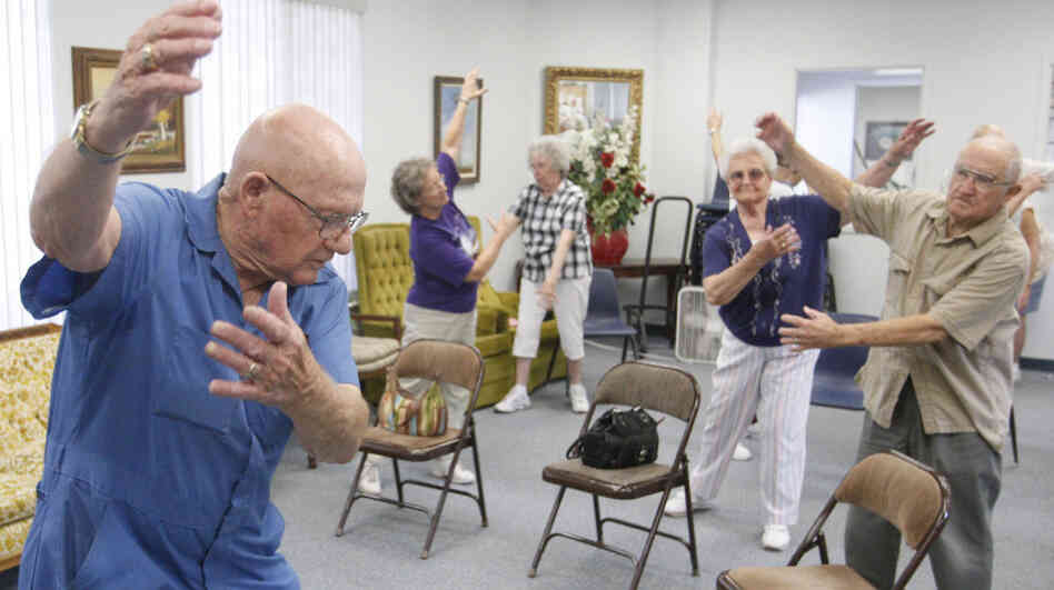Volunteer John Kelley (left) leads an exercise class at a senior center in Oklahoma on Monday. Centers such as these offer seniors a cool place to go during heat waves.
