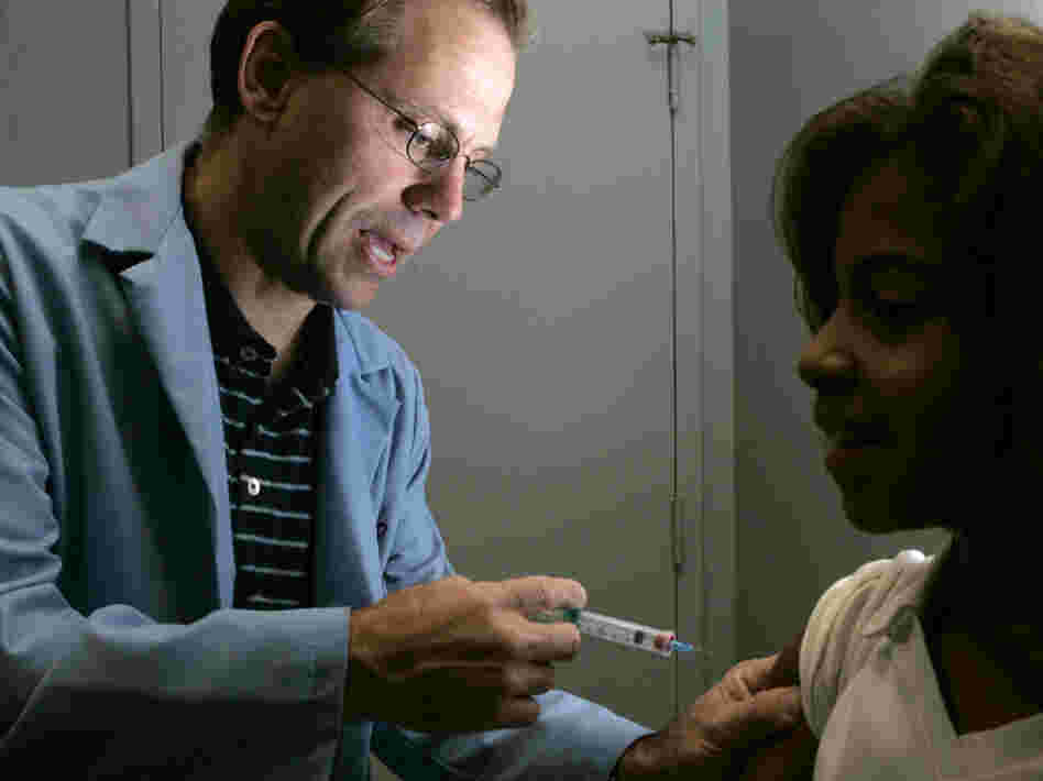 Dr. Donald Brown, left, gives 14-year-old Kelly Kent a dose of Gardasil, a vaccine for the human papillomavirus in 2006. The group that advises the U.S. government on vaccination recommendations is now starting to take costs for vaccines like Gardasil into consideration as vaccine prices rise.