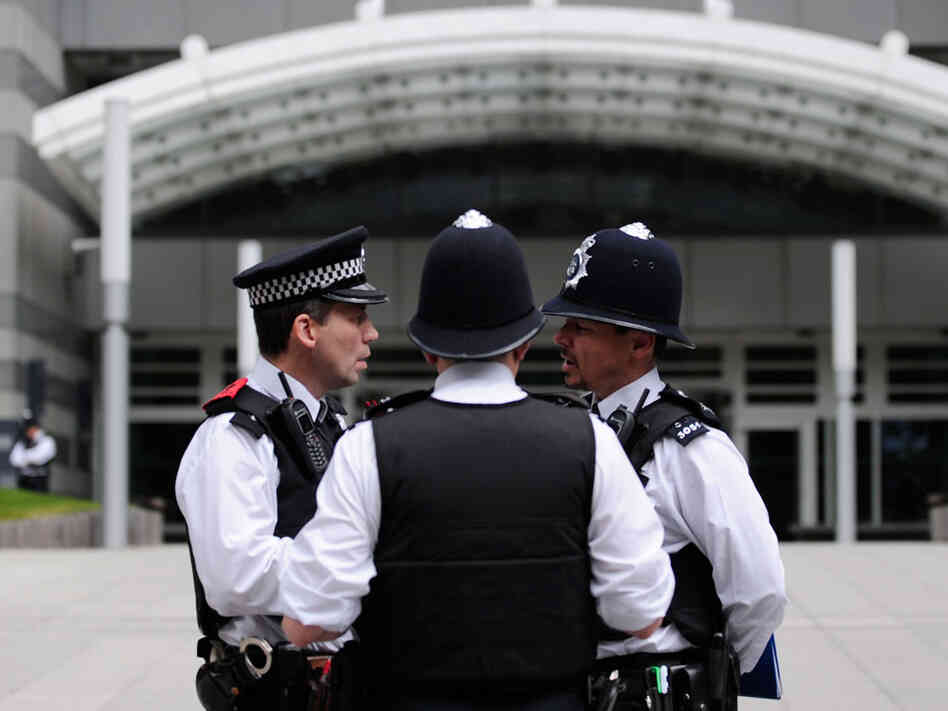 Police officers stand outside the News International offices in east London on July 10, 2011, as police inquiries continue into the News of the World phone hacking scandal. In the second hour, guests talk about the often complicated relationship between police and reporters. Police officers stand outside the News International offices in east London on July 10, 2011, as police inquiries continue into the News of the World phone hacking scandal. In the second hour, guests talk about the often complicated relationship between police and reporters.