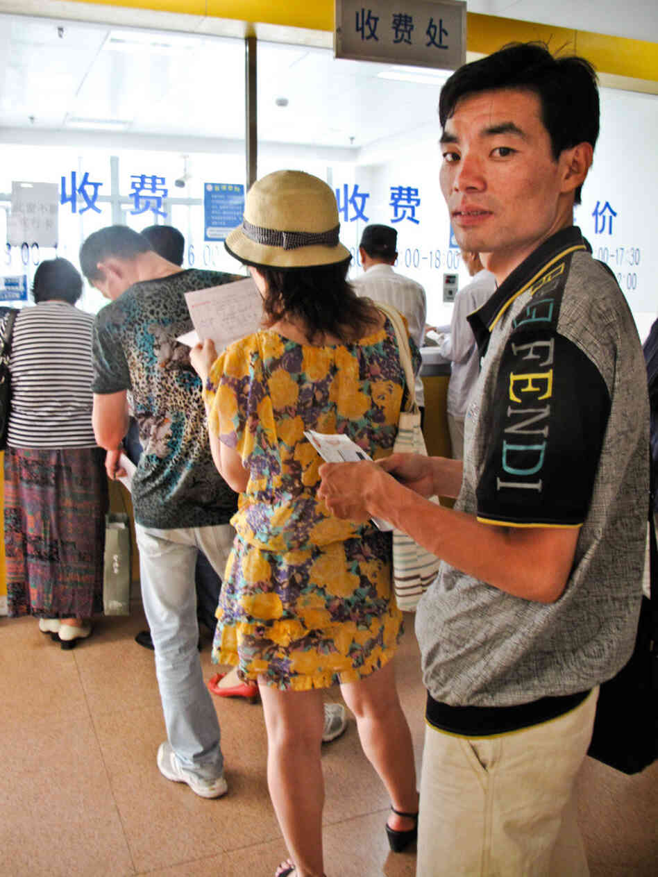 Queuer Li Qicai waits in line at a  Shanghai hospital to collect traditional Chinese  medicine for a customer. He says he does a dozen hospital jobs a  week.