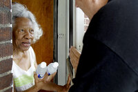 Lillie Walker, 90, accepts bottles of cold water on Monday in Jennings, Mo.