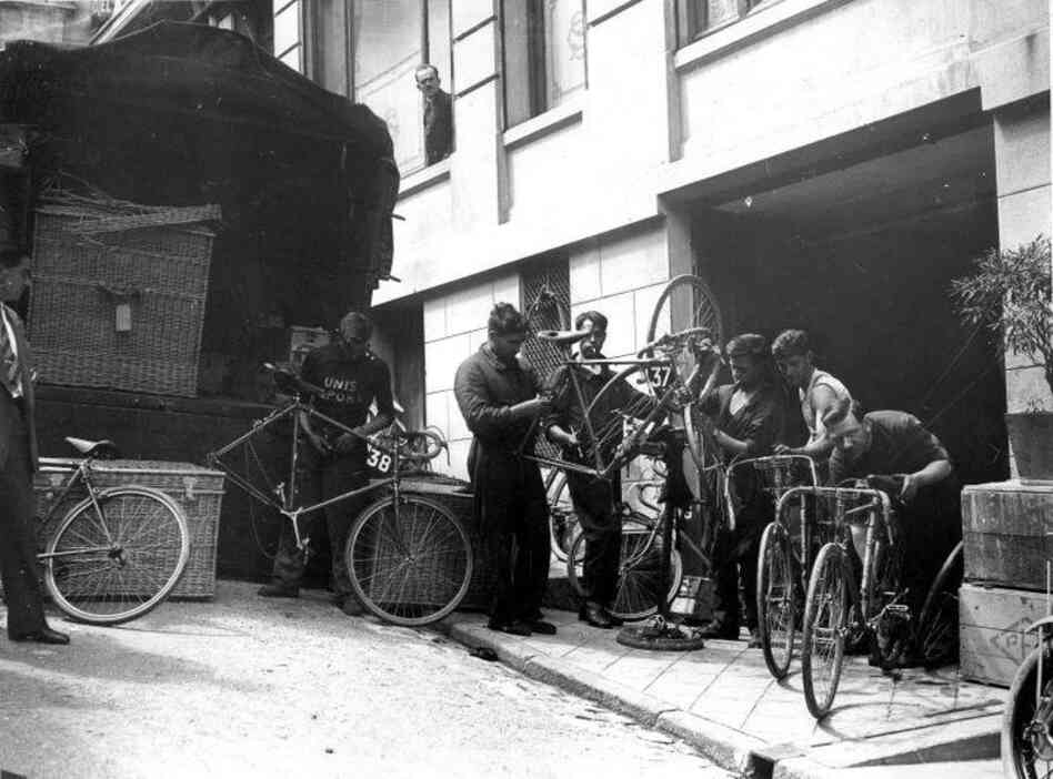 Cyclists in the 1930 race fix their bicycles during a rest day in Belfort. That year the Tour organizer, Henri Desgrange, ordered all cyclists to be formed into regional teams rather than manufacturers' teams. The participants all had to ride plain yellow bikes for the first time.