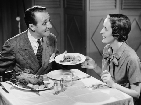 CIRCA 1950s:  Husband serving wife dinner.