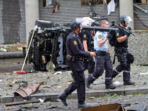 Rescue crew workers walk past a car flipped onto to its side after two bombs rocked the Norwegian capital of Oslo on Friday. Rescue crew workers walk past a car flipped onto to its side after two bombs rocked the Norwegian capital of Oslo on Friday.
