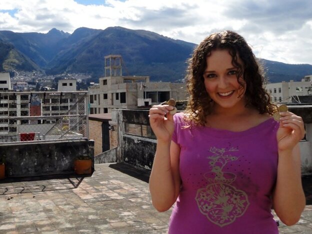 Teacher Rebecca Kayes shows off the dollar coins she uses in Quito, Ecuador.