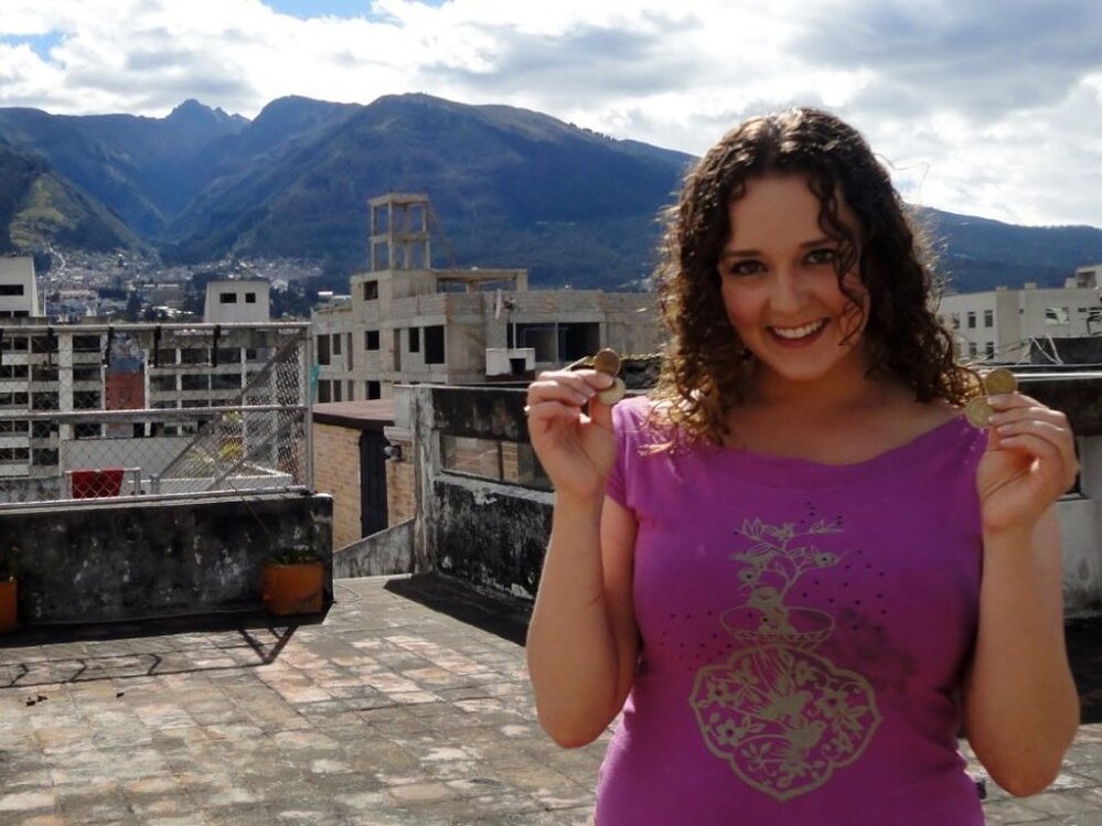 Teacher Rebecca Kayes shows off the dollar coins she uses in Quito, Ecuador.