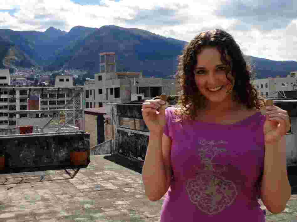 Teacher Rebecca Kayes shows off the dollar coins she uses in Quito, Ecuador.