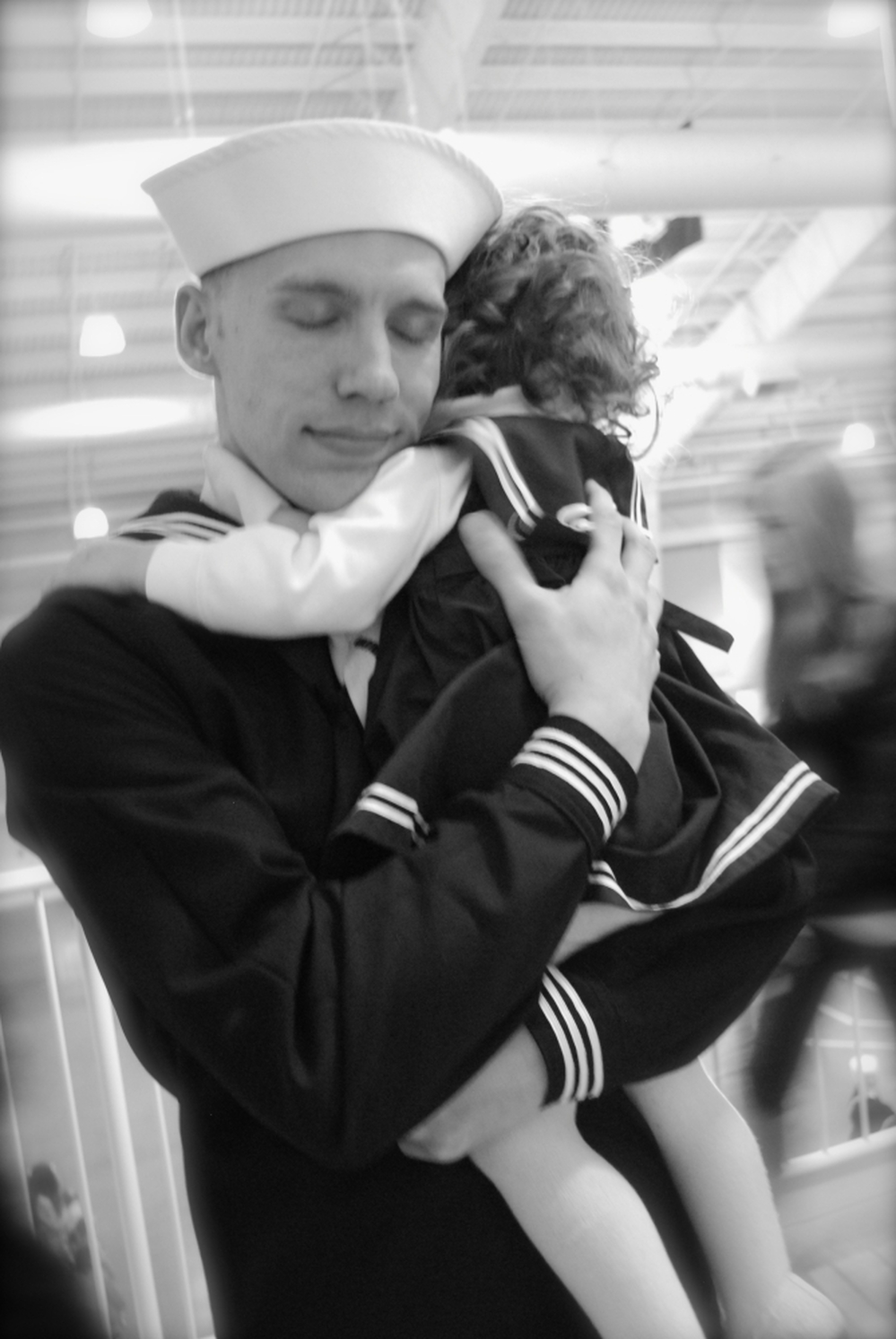 Justin Bock holds his daughter, Lina, at his graduation from basic training earlier this year. Bock decided to enlist in the Navy after both he and his wife, Ashley, were laid off.