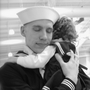 Justin Bock holds his daughter, Lina, at his graduation from basic training earlier this year. Bock decided to enlist in the Navy after both he and his wife, Ashley, were laid off.