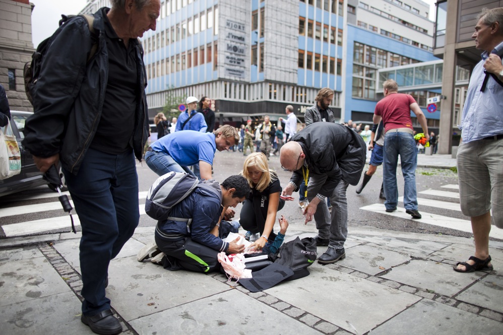 People tend to a wounded person after the explosion. 