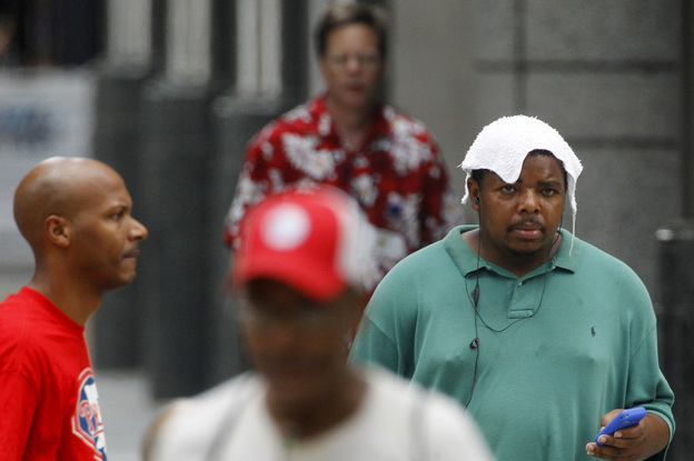 Pedestrians walk along Market Street in Philadelphia on Friday, as the temperature topped 100 degrees.