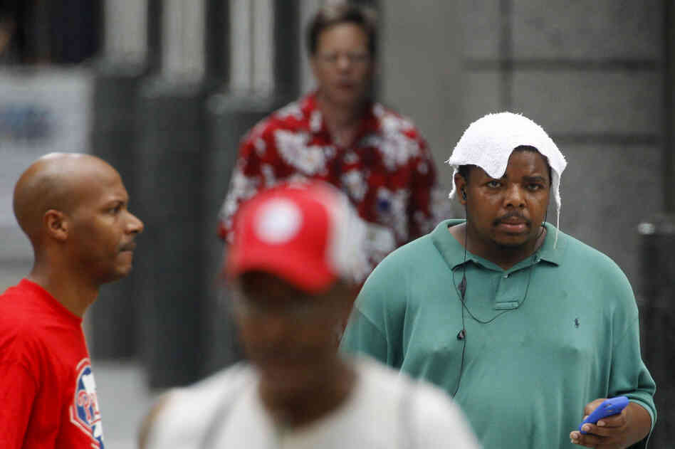 Pedestrians walk along Market Street in Philadelphia on Friday, as the temperature topped 100 degrees.