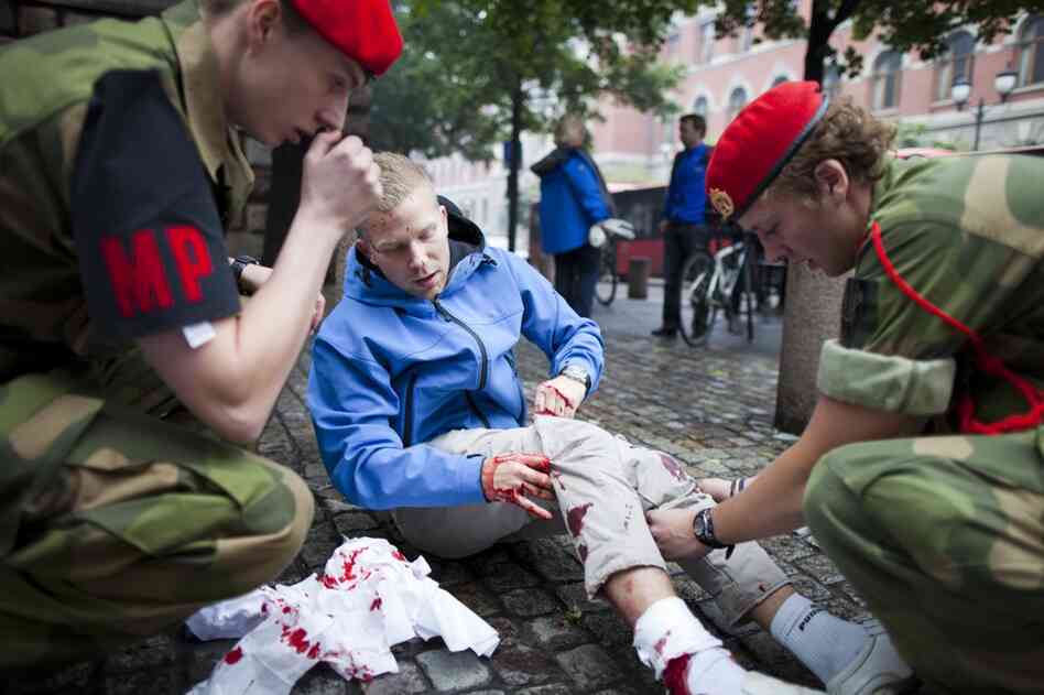 An injured man is treated at the scene. 