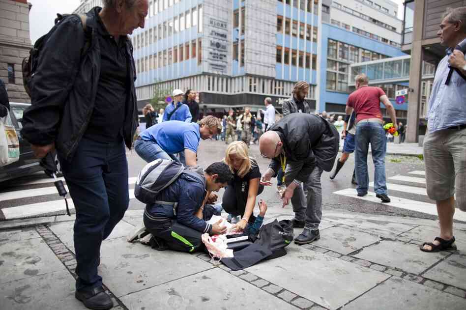 People tend to a wounded person after the explosion. 