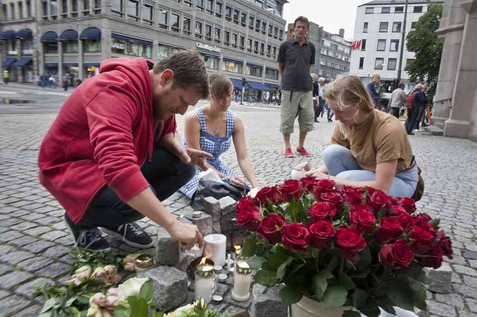 People light candles and lay flowers in central Oslo, Norway, on Saturday to pay tribute to the victims of twin attacks a day earlier. At least 91 people died in an explosion at government offices in the capital and a shooting at a youth camp on nearby Utoya island. 