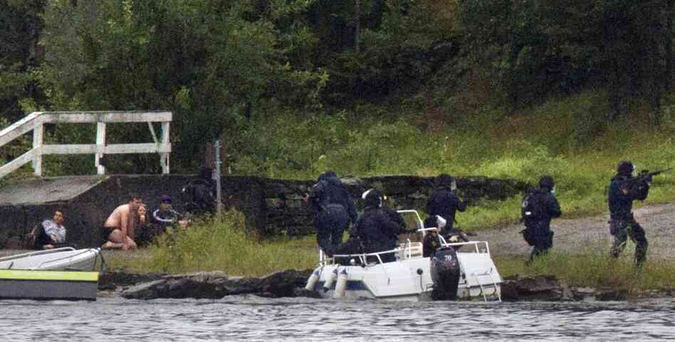 SWAT team members aim their weapons while people take cover during a shootout on the island Friday. 