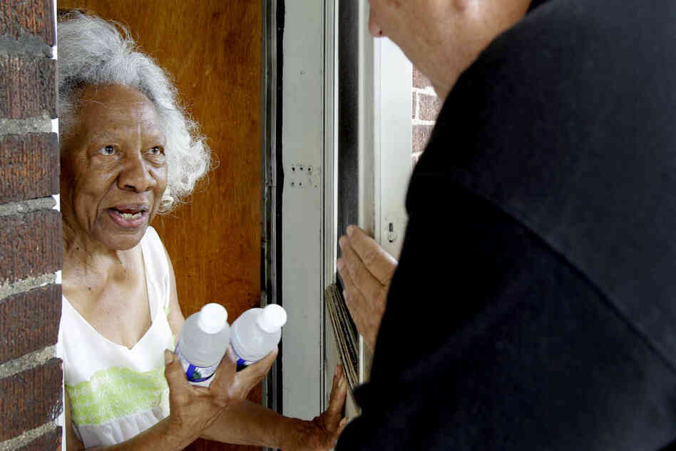 Lillie Walker, 90, accepts bottles of cold water on Monday in Jennings, Mo. 