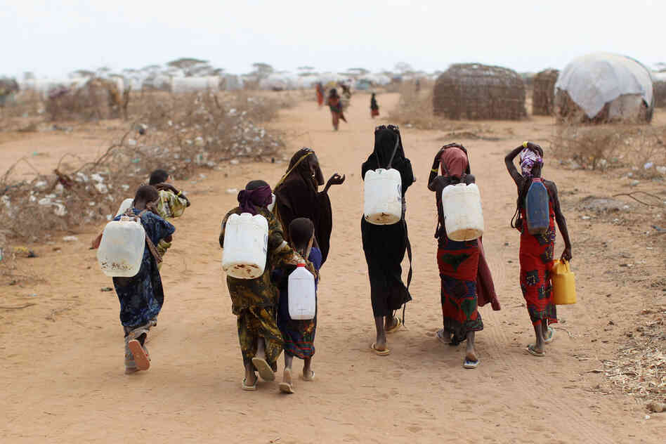 Somali refugees return from collecting water July 22 at the edge of the Dagahaley refugee camp, also part of the Dadaab settlement. 