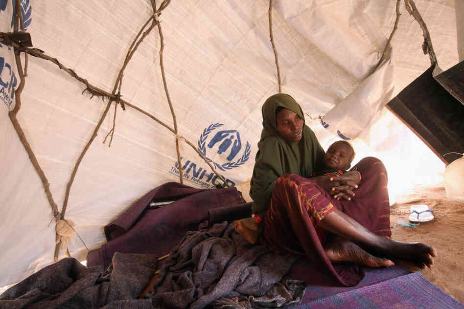 A Somali refugee mother and child sit in their makeshift hut on the edge of the Hagadera refugee camp on July 24. The camp makes up part of the giant Dadaab refugee settlement. 