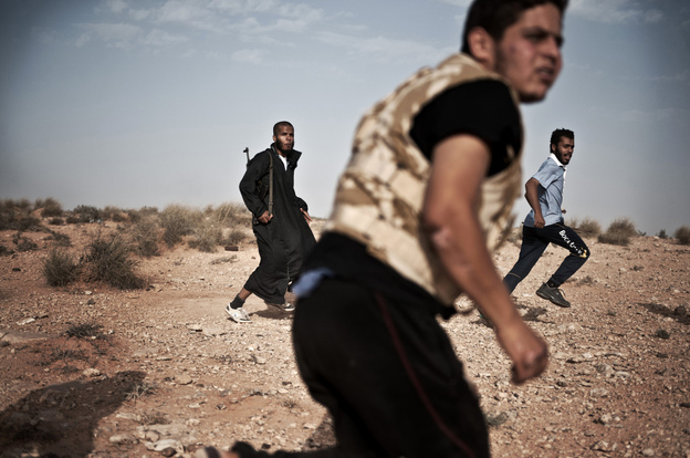 Libyan rebel fighters run for cover at the front line near the southwest desert town of Gualish on July 24, as Gadhafi forces started attacking them in an attempt to capture the city. Libyan rebel fighters run for cover at the front line near the southwest desert town of Gualish on July 24, as Gadhafi forces started attacking them in an attempt to capture the city.