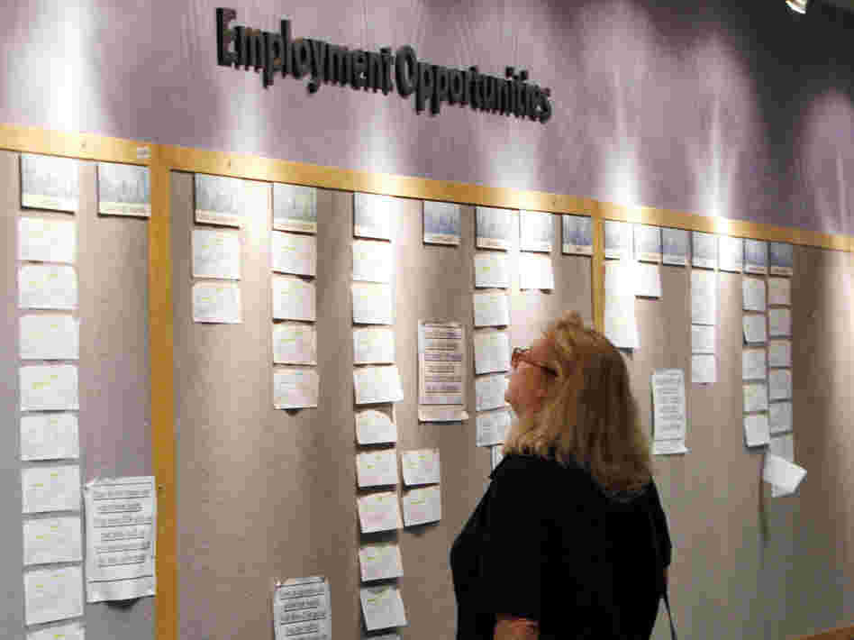 Lori Kamlet looks at posted job opportunities at a Denver employment office last Friday.