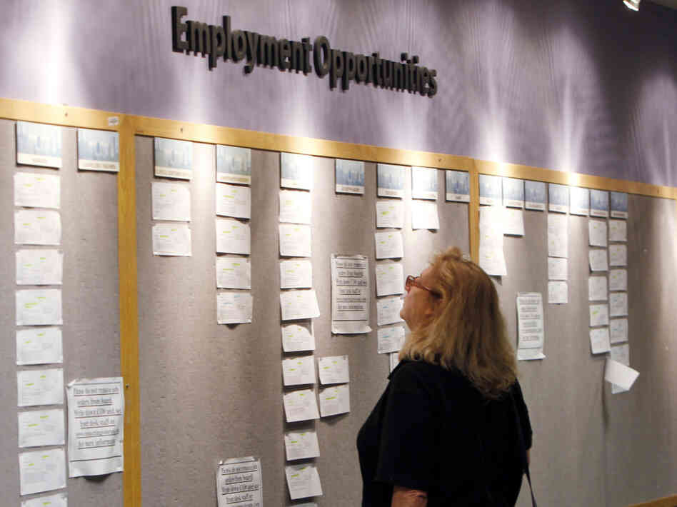 Lori Kamlet looks at posted job opportunities at a Denver employment office last Friday.