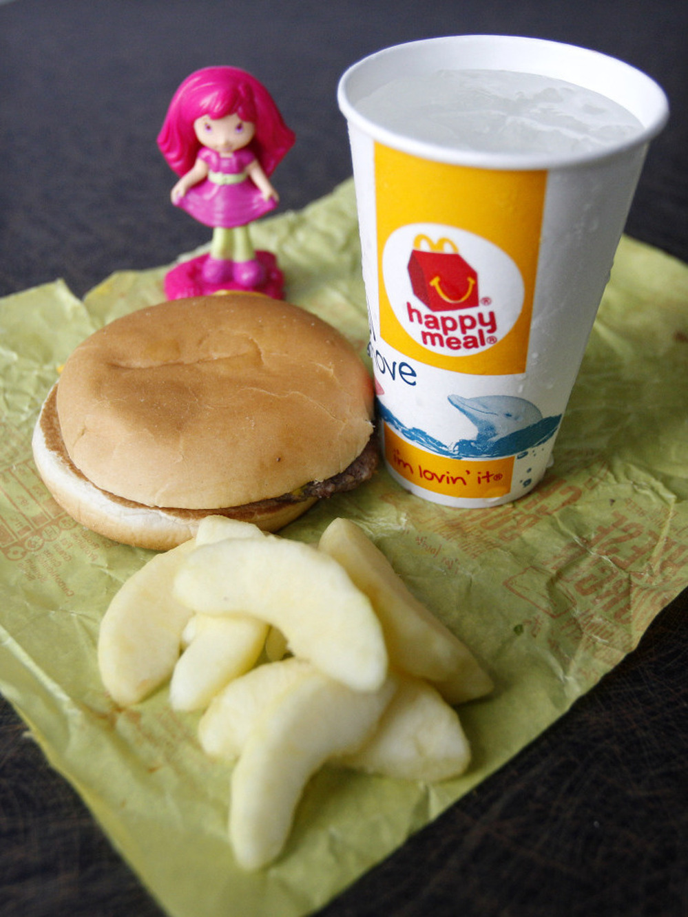 A McDonald's Cheeseburger Happy Meal with the new apple slices option is shown Tuesday. McDonald's Corp. says it is adding apple slices to every Happy Meal, part of the chain's larger push to paint itself as a healthy place to eat.