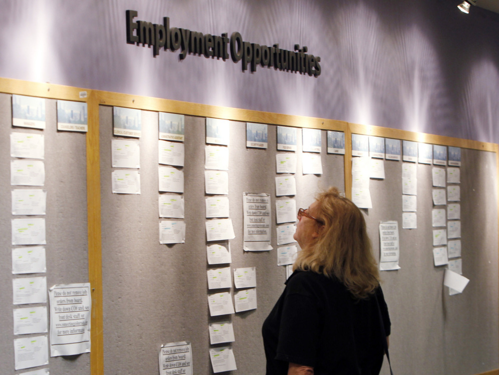 A woman looks at posted job opportunities at a Denver employment office last Friday.