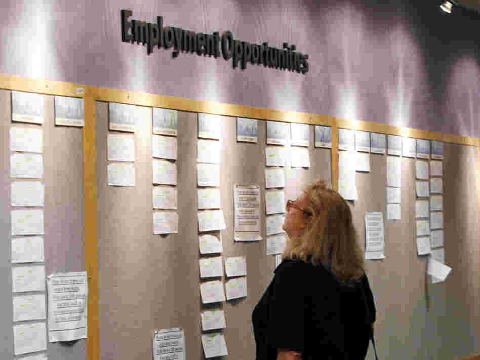A woman looks at posted job opportunities at a Denver employment office last Friday.