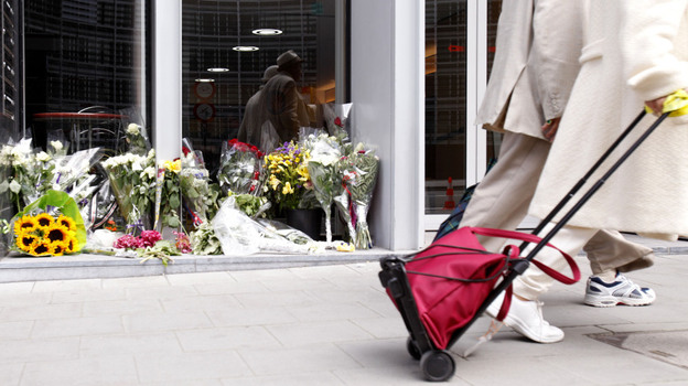 Two people walk by a flower memorial in front of the Norway House in Brussels on Thursday, July 28, 2011. The EU convened a special meeting on counterterrorism in Brussels on Thursday, following the Norway massacre, in which at least 76 people were killed.