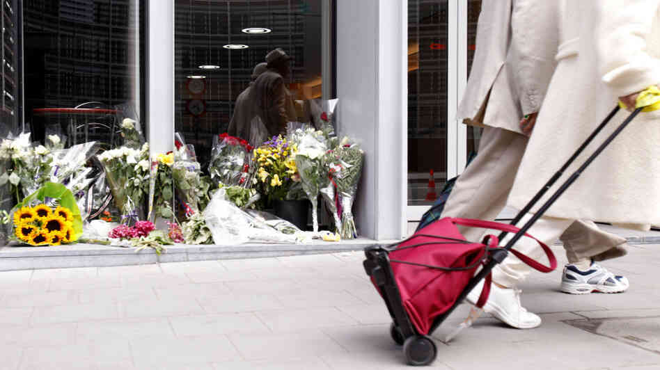 Two people walk by a flower memorial in front of the Norway House in Brussels on Thursday, July 28, 2011. The EU convened a special meeting on counterterrorism in Brussels on Thursday, following the Norway massacre, in which at least 76 people were killed.