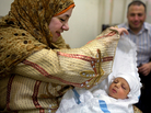Israa Saad Diab lifts the cover from her son Hamza's face, while her husband, Ibrahim Muhammad, watches, after the traditional Sebou ceremony in Mansoura, Egypt, on May 27. Israa Saad Diab lifts the cover from her son Hamza's face, while her husband, Ibrahim Muhammad, watches, after the traditional Sebou ceremony in Mansoura, Egypt, on May 27.