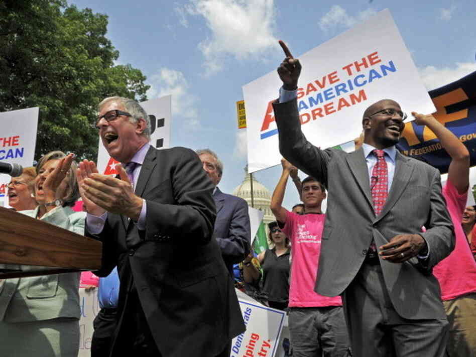 Van Jones (right) of the American Dream Movement, points skyward during a sing-along in front of the Capitol to urge lawmakers to come to a fair deal on the budget on Thursday. At the microphone is Joel Silberman, also with the American Dream Movement.