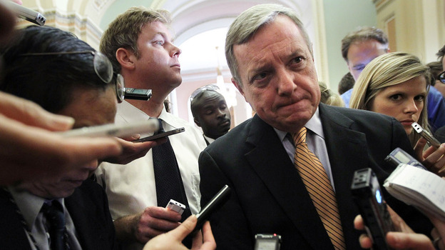 U.S. Senate Majority Whip Richard Durbin (D-IL) is surrounded by reporters at the Capitol Friday after a briefing on the debt ceiling.