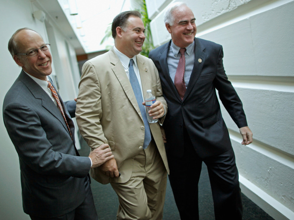 Rep. Greg Walden (R-OR) (L) and Rep. Patrick Meehan (R-PA) (R) pretend to twist the arms of Rep. Frank Guinta (R-NH), July 29. 2011.