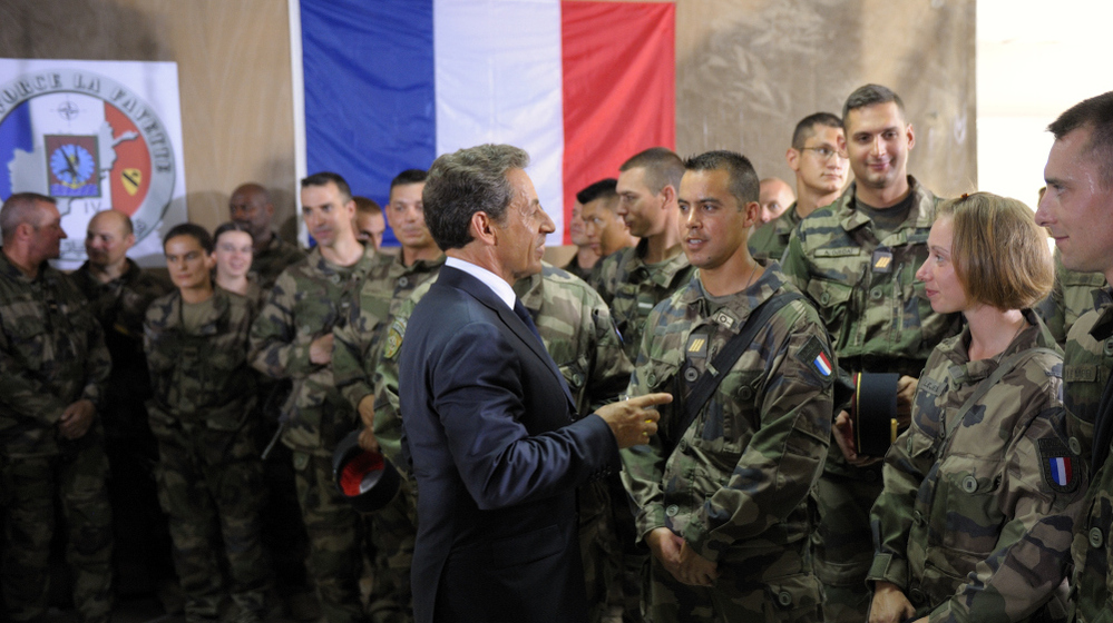 French President Nicolas Sarkozy speaks with French troops at the 152nd Infantry Regiment military base in the region of Surobi, Afghanistan, in July. Analysts say the French military has been strained by restructuring, budget cuts and simultaneous conflicts abroad.