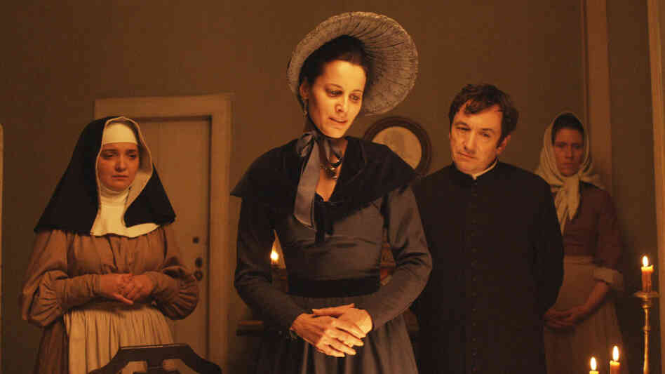 Moving In Mysterious Ways: Over the course of its 4 1/2 hours, the film tracks, abandons and reconnects with characters of various social classes, including Angela de Lima (Maria Joao Bastos, center), mother to protagonist Pedro, and Father Dinis (Adriano Luz), who looks after Pedro as a boy. Moving In Mysterious Ways: Over the course of its 4 1/2 hours, the film tracks, abandons and reconnects with characters of various social classes, including Angela de Lima (Maria Joao Bastos, center), mother to protagonist Pedro, and Father Dinis (Adriano Luz), who looks after Pedro as a boy.