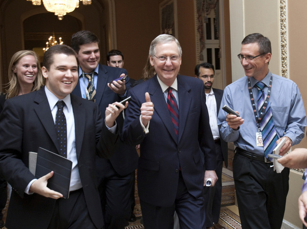 Senate Republican Leader Mitch McConnell of Kentucky (center) walks to the Senate floor to announce that a deal has been reached on the debt ceiling on Capitol Hill on Sunday.
