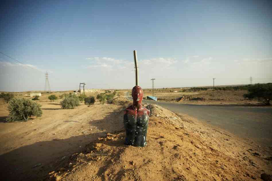Photojournalist Jonathan Levinson recently spent time in Libya documenting the rebel forces. In this photo essay, he shows how the rebels are reusing old weapons. Here, a silhouette designed for target practice is painted with the colors of the rebel flag and staked on top of a berm at a checkpoint in the Nafusa Mountains in western Libya.