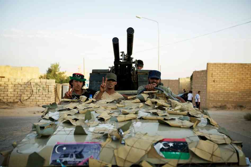 Rebels drive through the streets of Zintan in a modified Toyota Land Cruiser with the roof cut off and a ZPU-2 anti-aircraft gun mounted on the back.