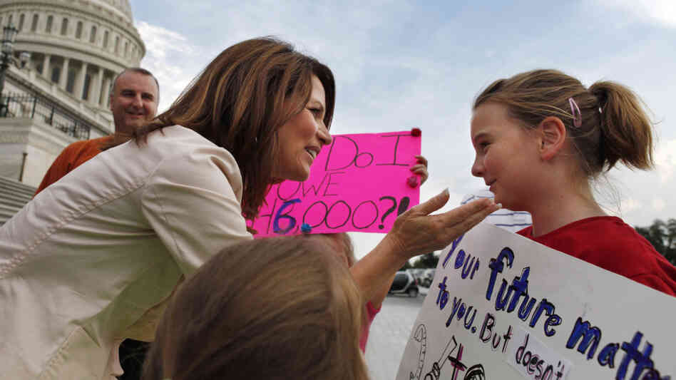 Republican presidential candidate Michele Bachmann (R-MN), greets Ellie Joy Matthews, 11, of Kansas City, Mo., as she and her family hold signs supporting a balanced budget amendment on Monday, just before the House would vote to pass debt legislation. Republican presidential candidate Michele Bachmann (R-MN), greets Ellie Joy Matthews, 11, of Kansas City, Mo., as she and her family hold signs supporting a balanced budget amendment on Monday, just before the House would vote to pass debt legislation.