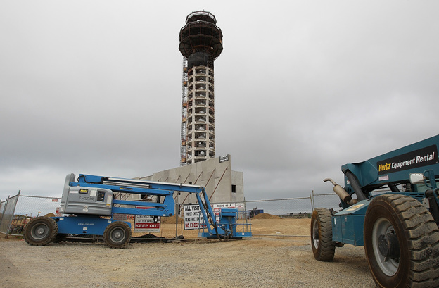 Construction equipment sits idle in front of the half-completed new control tower at Oakland International Airport. Thousands of construction workers on aviation projects have stopped work, as a standoff over funding of the FAA continues.