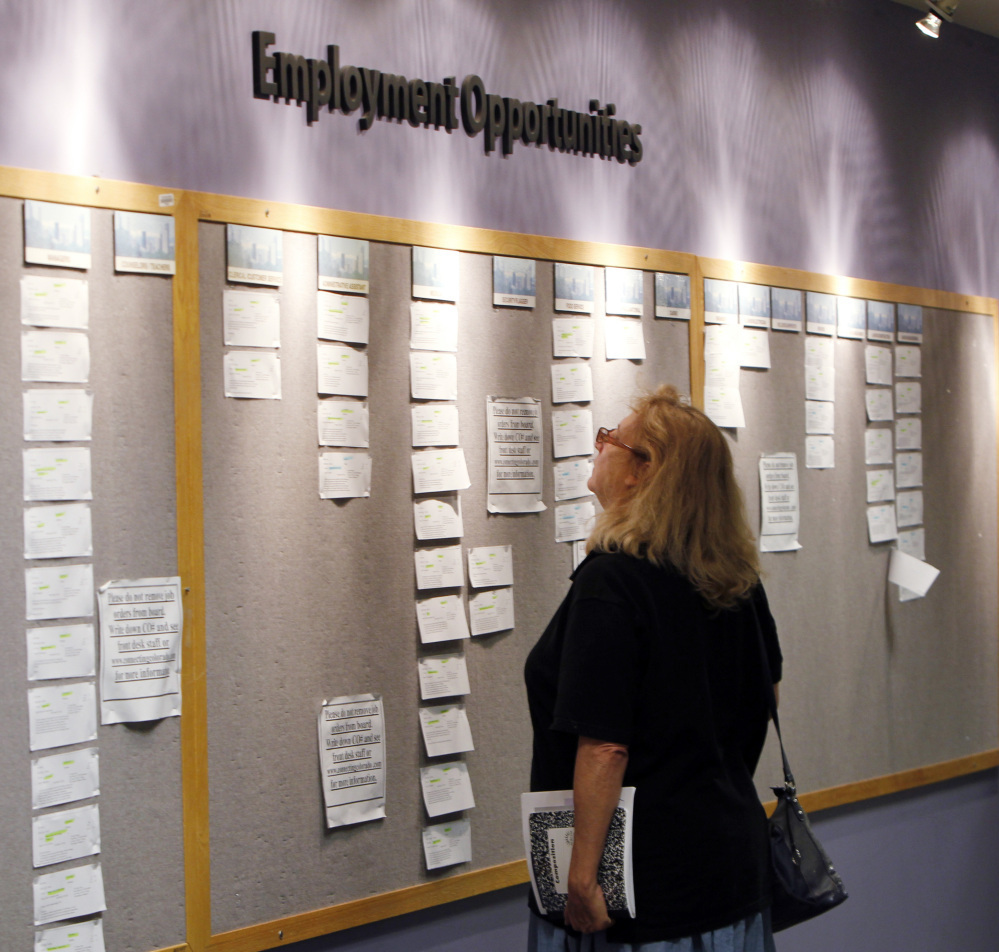 Lori Kamlet looks at posted employment opportunites at a Denver Employment office on Friday, July 22, 2011.