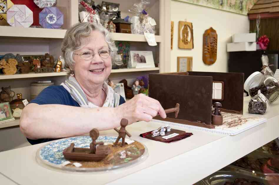 LaDonna Secrist, owner of speciality chocolate shop Squirrel's Den, shows off her chocolate recreations of scenes from The Shawshank Redemption. In her hand, a chocolate rock hammer. At left, a chocolate Andy and Red reuniting on the beach in Zihuatanejo.