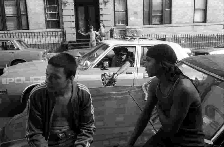 New York City police stop their car to check out two youths, who are not selling drugs, but who are hanging out on a known drug corner,  1980s.