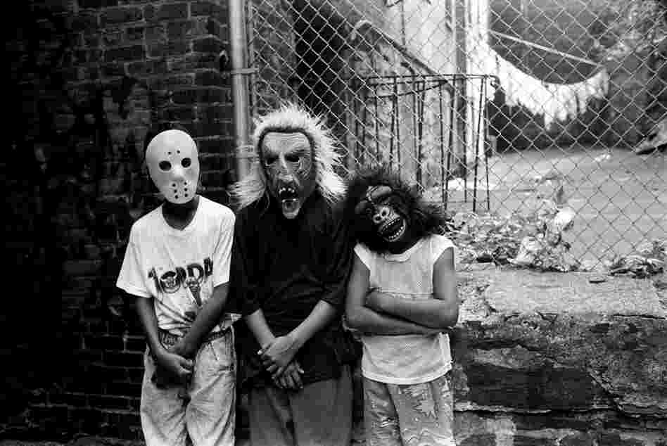 Three teenage boys wear Holloween masks, 1990s