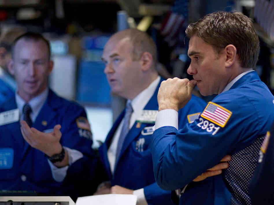 Traders work on the floor of the New York Stock Exchange on Thursday. Stocks sank again as investors continued to fret about the struggling economies in Europe and slow growth in the U.S.